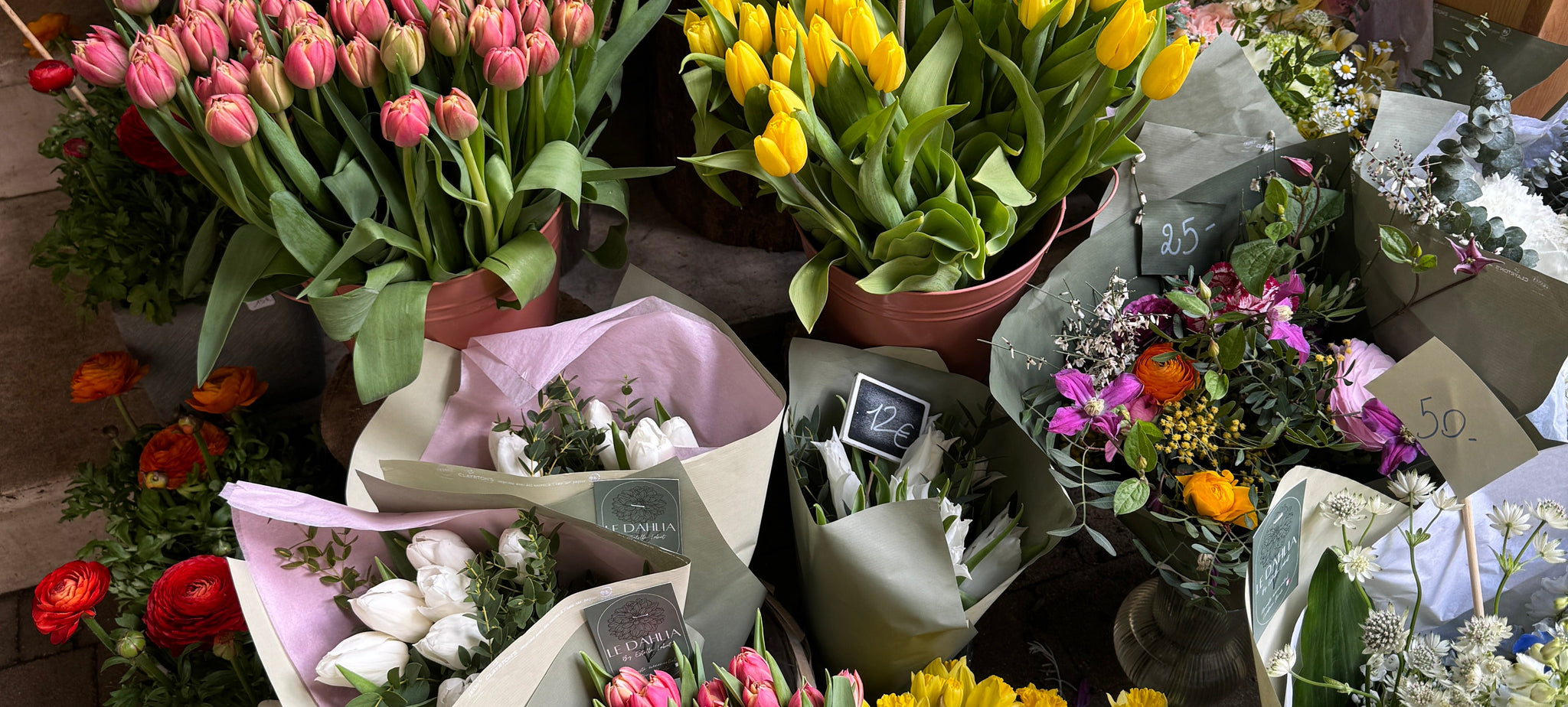 Bouquets of flowers displayed outdoors on a sidewalk